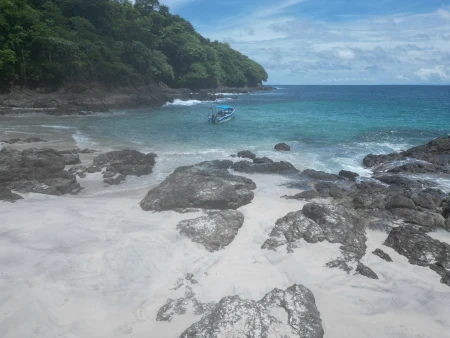 Un impresionante vistazo a la majestuosidad de Isla Caleta, capturado a pleno medio día, destacando sus extensas playas de arena blanca y las aguas cristalinas que rodean este paraíso de la pesca deportiva en Panamá.