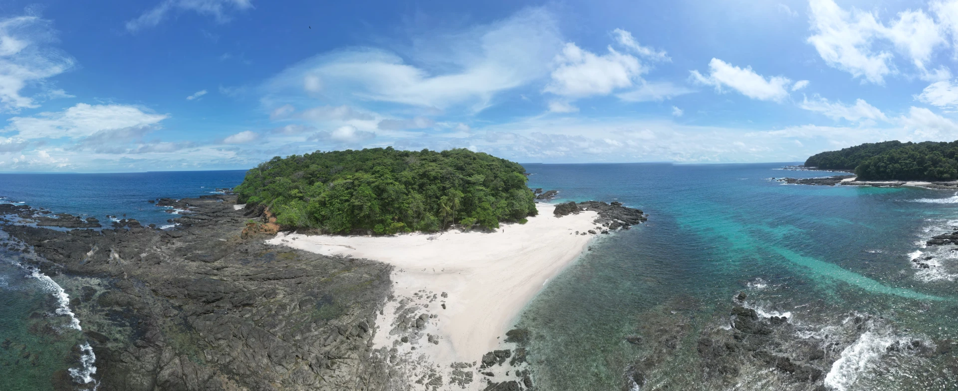 Un impresionante vistazo a la majestuosidad de Isla Caleta, capturado a pleno medio día, destacando sus extensas playas de arena blanca y las aguas cristalinas que rodean este paraíso de la pesca deportiva en Panamá.