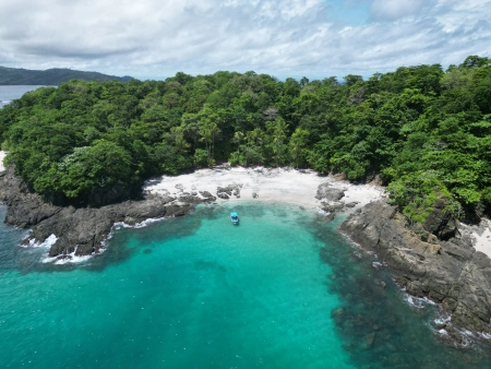 Tres Islas (Isla Caleta) - Esta foto muestra una vista panorámica de Isla Caleta en un día nublado de noviembre. La isla se alza majestuosamente en medio del océano, rodeada de aguas azules y exuberante vegetación costera.