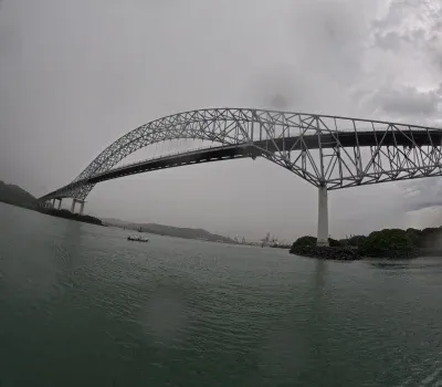 Esta impresionante fotografía captura la imponente belleza del Puente de las Américas en Panamá, una estructura icónica que conecta los continentes de América del Norte y América del Sur. La imagen muestra el imponente arco del puente, resaltando su diseño arquitectónico único y su importancia histórica como uno de los enlaces más emblemáticos del continente. La vista panorámica revela el puente extendiéndose a través del Canal de Panamá, con el agua reluciente debajo y la ciudad de Panamá de fondo. Esta foto simboliza la unión de culturas, comercio y progreso, y es un testimonio de la ingeniería impresionante que une a las Américas.