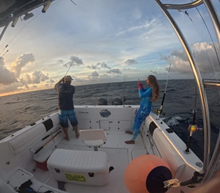 El sol se pone sobre las cristalinas aguas de Puerto Morelos, ofreciendo un impresionante espectáculo natural mientras Mónica se prepara para su próxima captura.