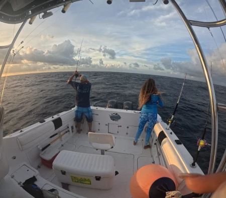 Mónica López perfeccionando su técnica de jigging en las tranquilas aguas de Puerto Morelos, con la magnificencia del atardecer como telón de fondo.